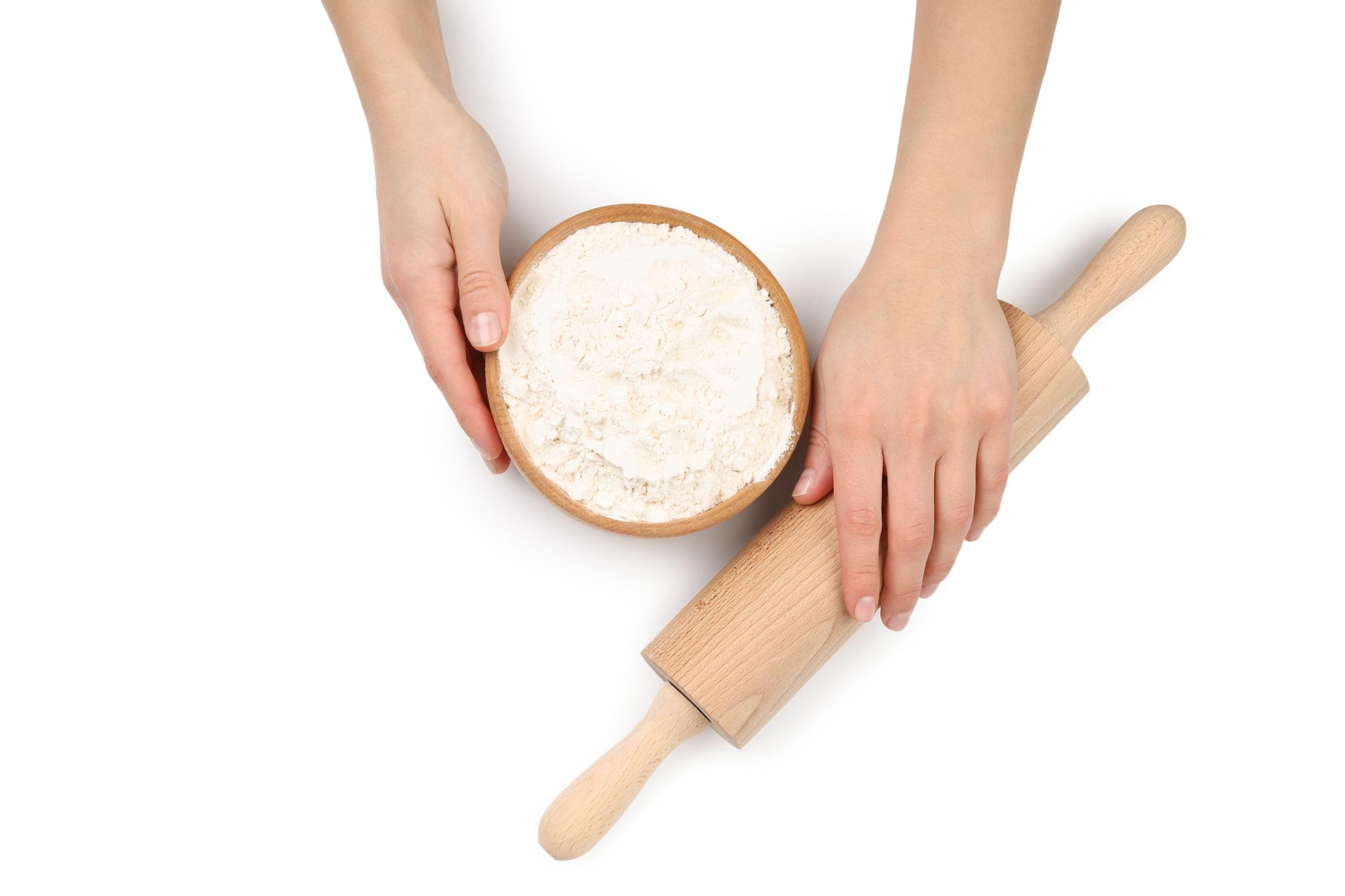Hands kneading dough on floured board