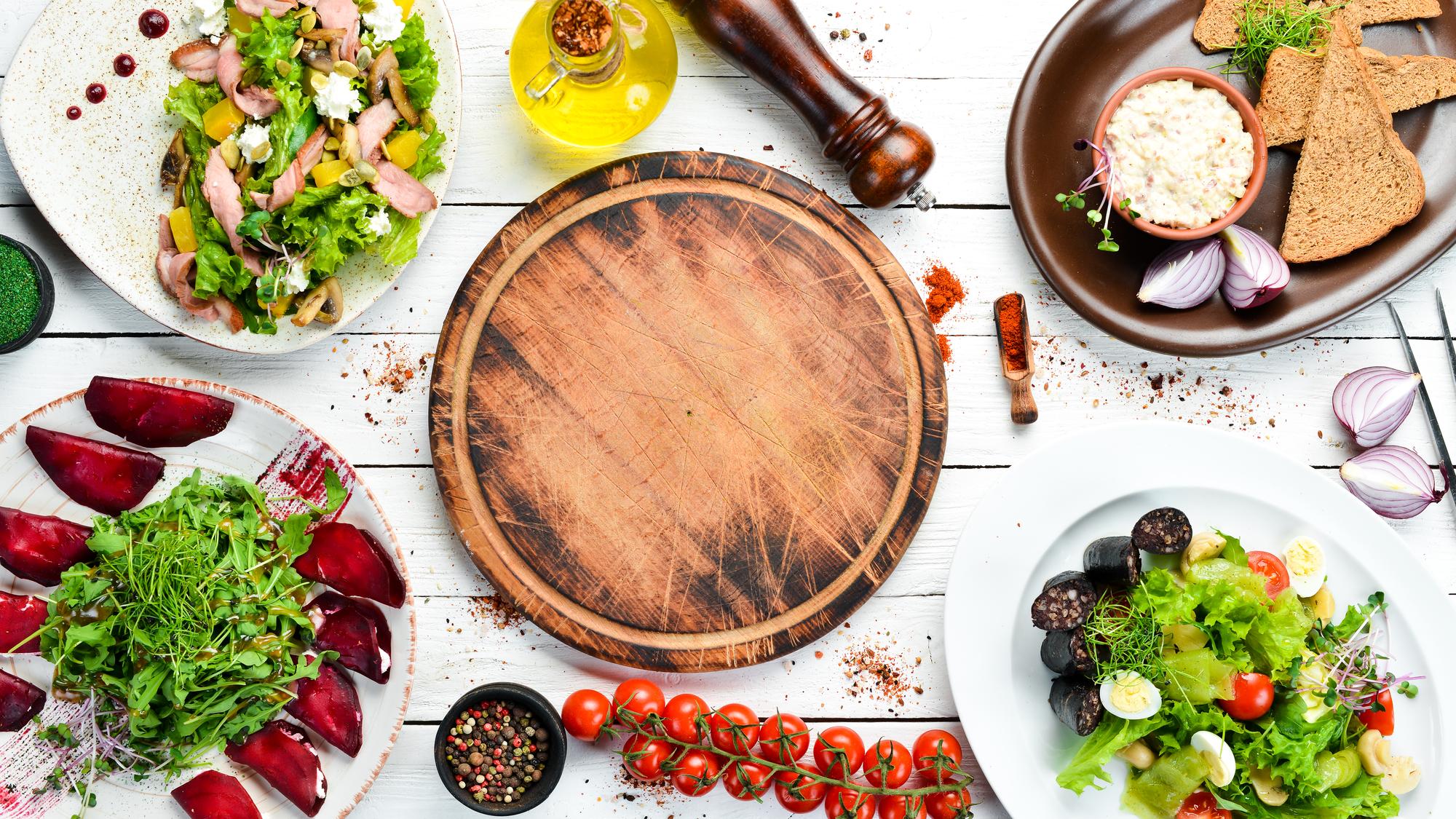 Array of plated dishes on wooden board